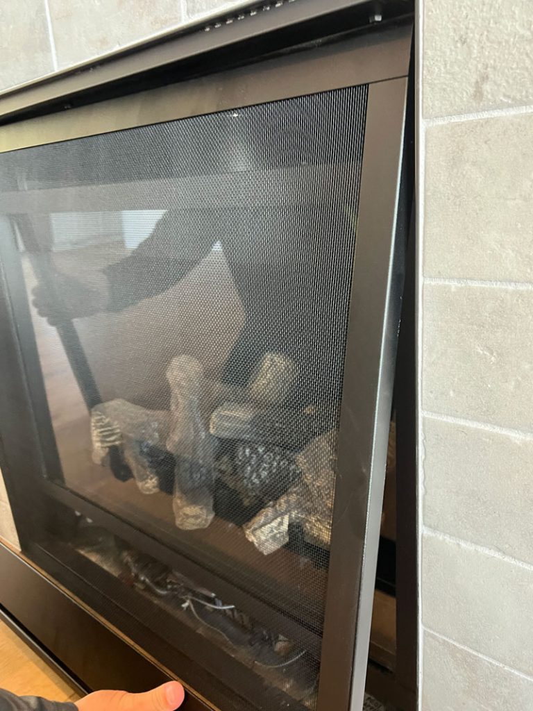 Screen being placed back into fireplace