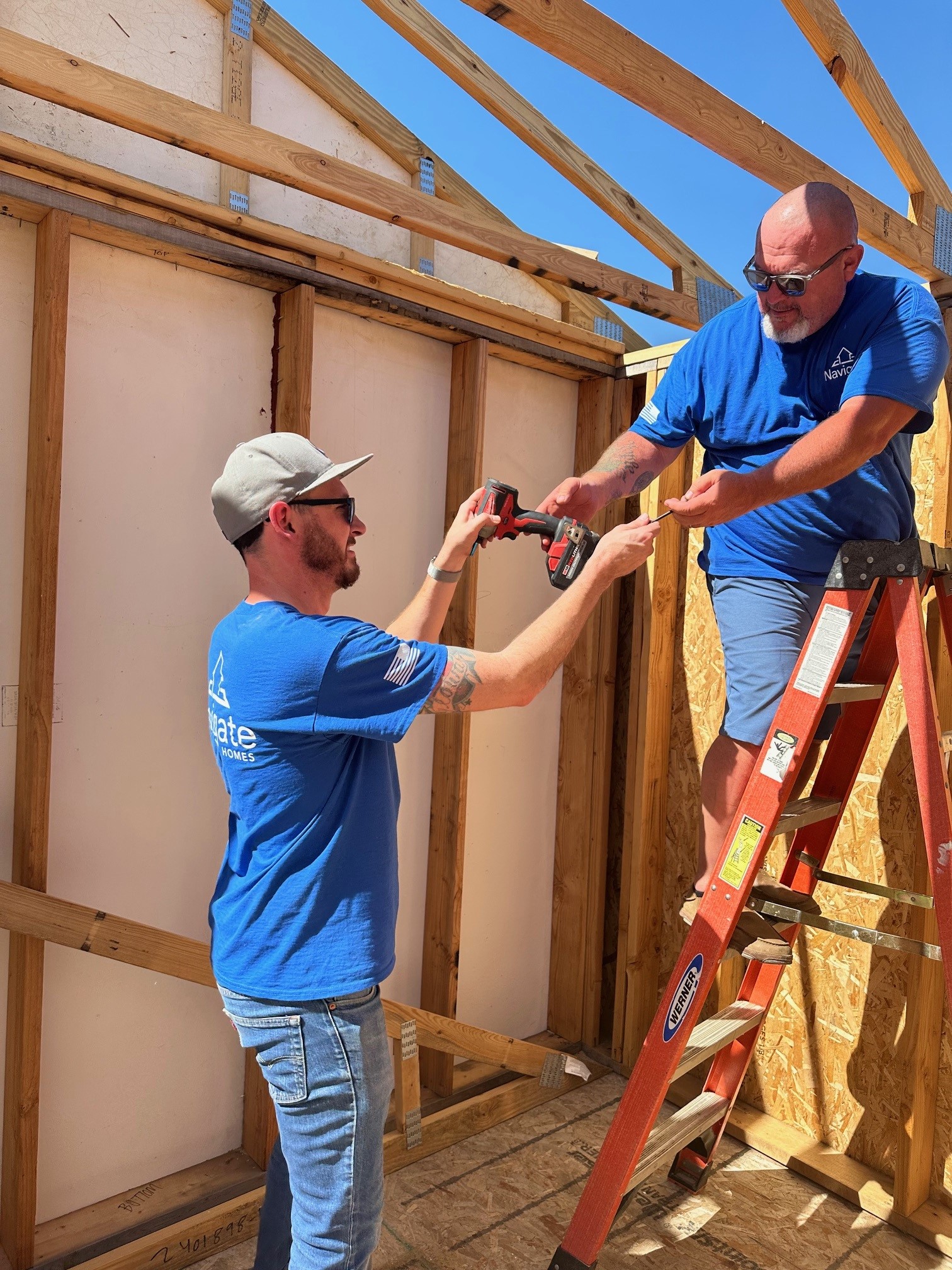 Navigate Homes volunteers working together on the framing of a home