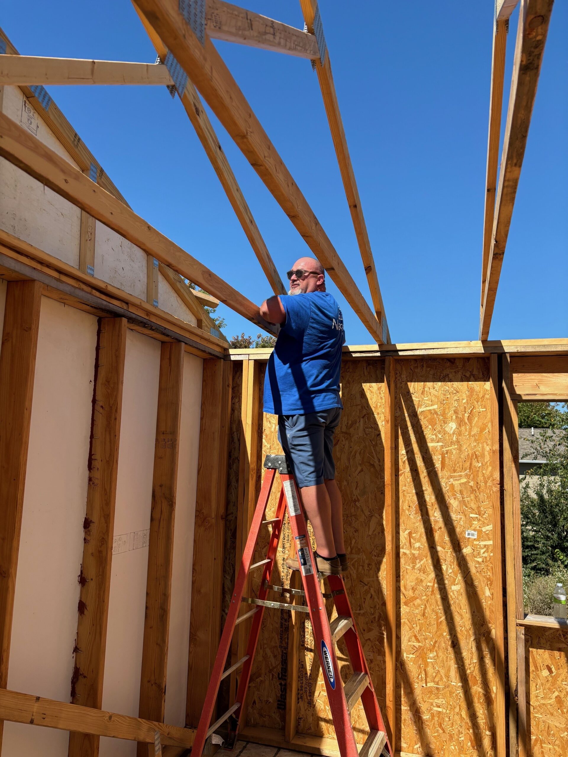 Navigate Homes volunteer helping install roof trusses