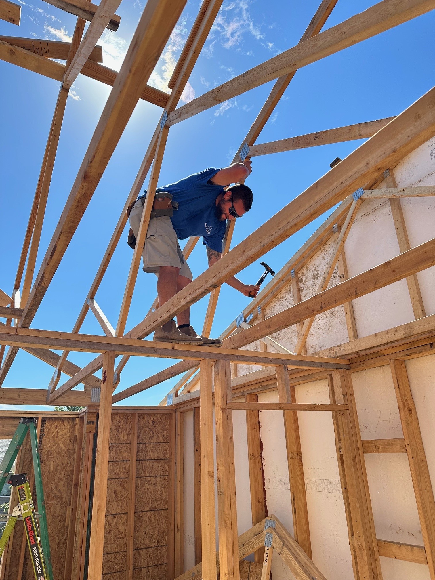 Navigate Homes volunteer securing roof framing during a home build