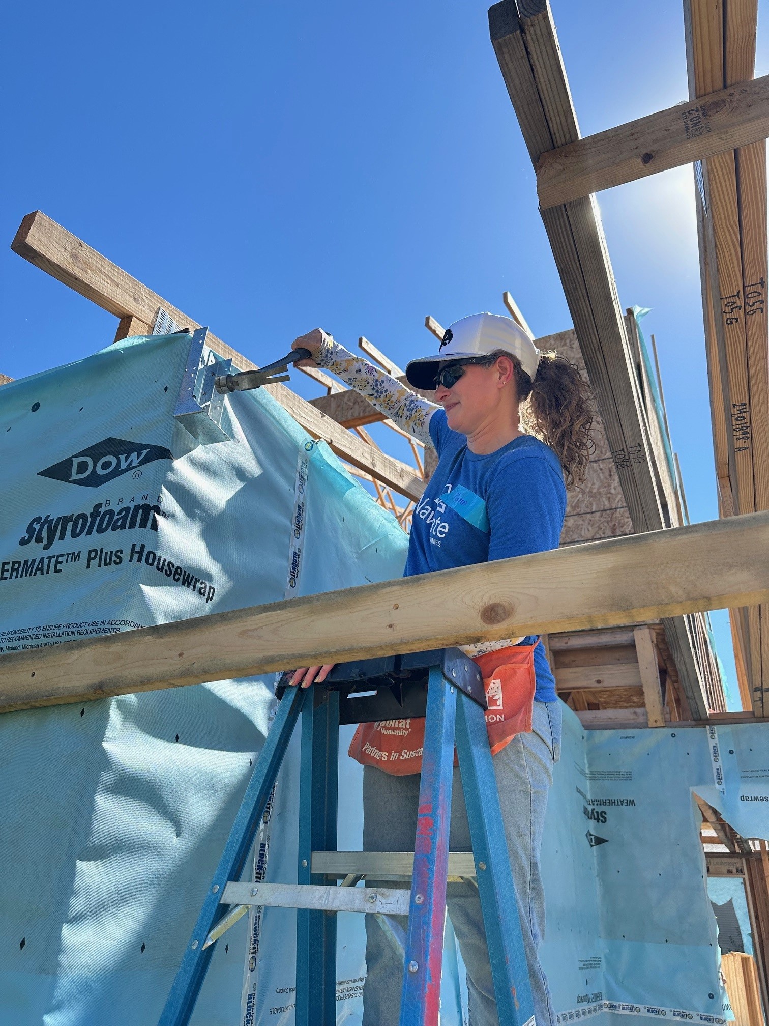 Navigate Homes volunteer installing exterior house wrap